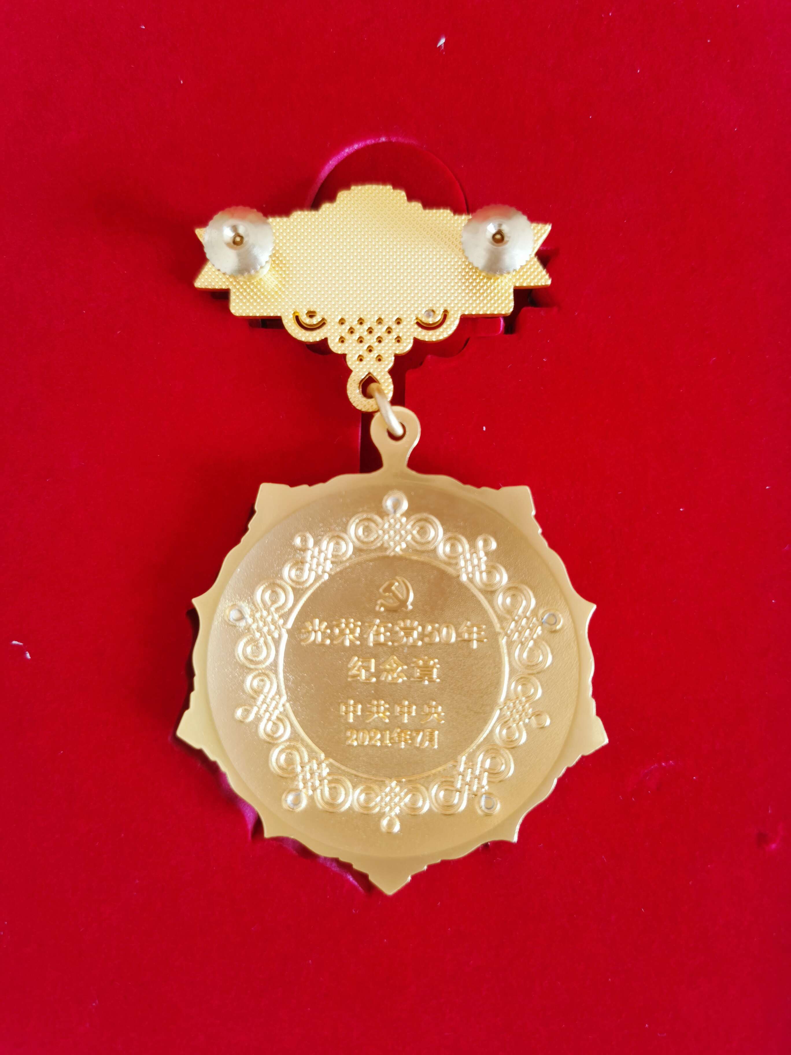 光榮在黨50年紀念獎章背面。  閆慧/攝